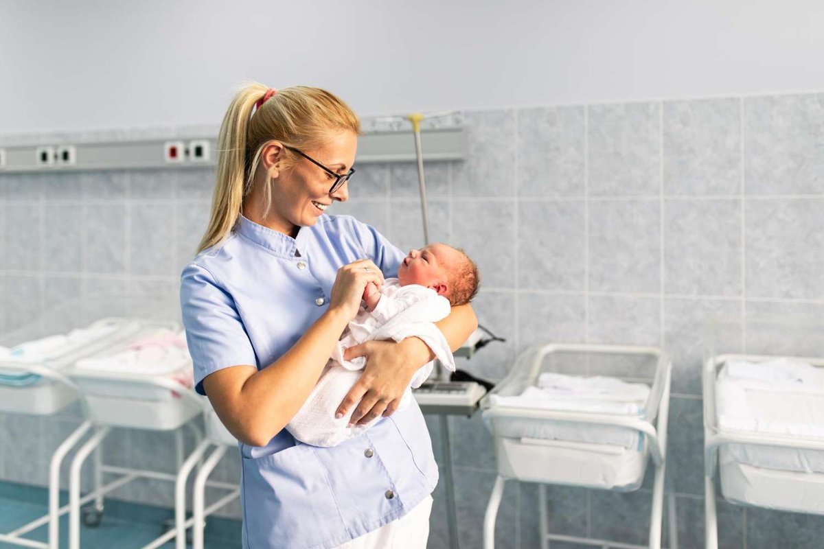 A neonatologist holds a baby