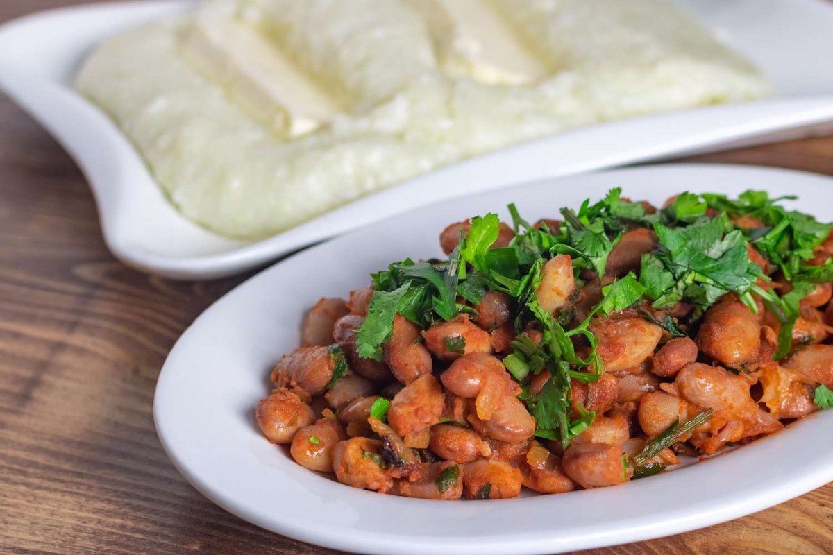 A serving of beans with khmeli-suneli and puri against a backdrop of mountains
