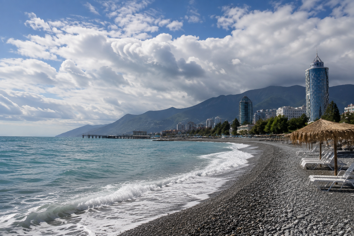 A peaceful Batumi beach in September, with gentle waves, pebble shores, beach loungers and dramatic clouds over the Black Sea.
