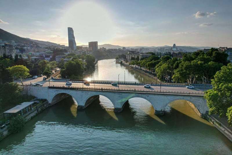 An arched stone bridge across the Kura River in Tbilisi