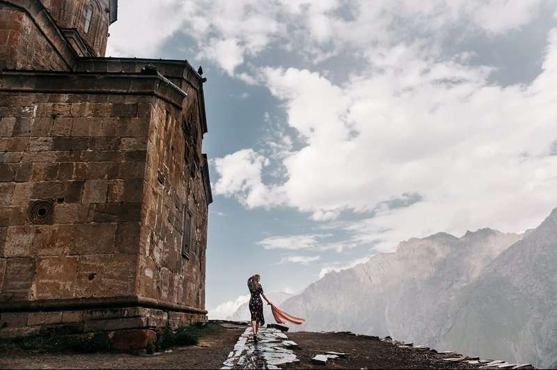 A girl against the backdrop of Mount Kazbegi