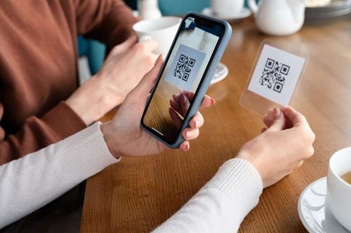 Close-up of hands scanning a QR code
