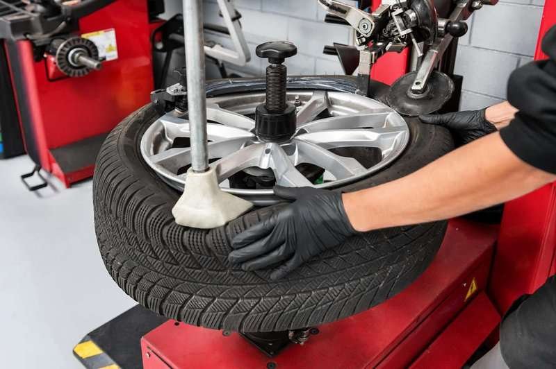 A mechanic removes a tire from a wheel