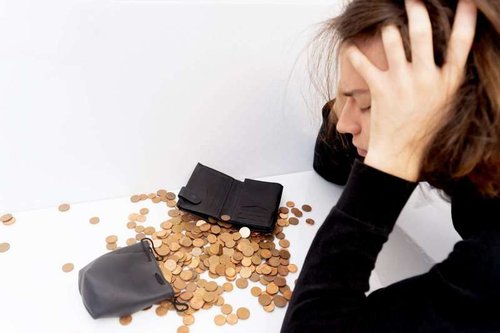 A young man holds his head in his hands due to the constant costs of website development.