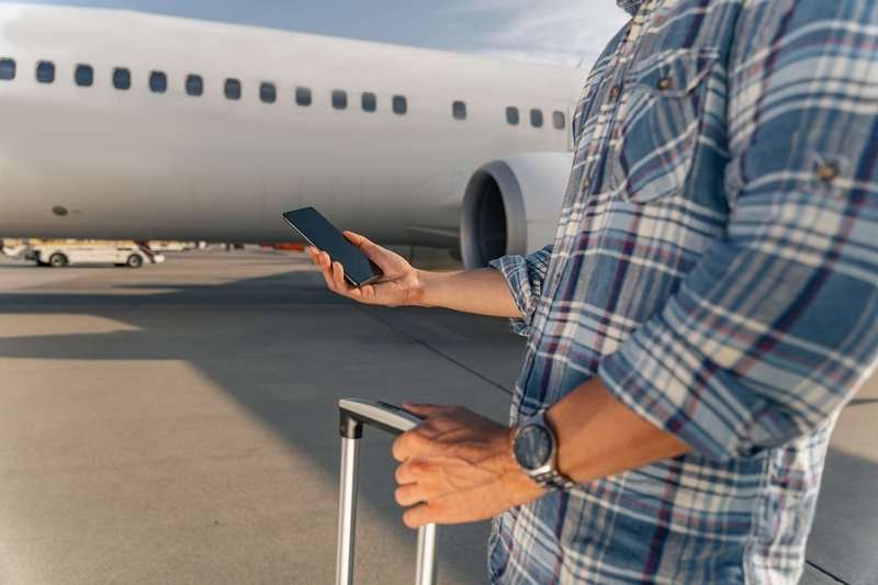 a man with a phone near an airplane
