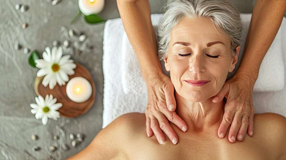 Пожилая женщина наслаждается массажем головы в спа-салоне