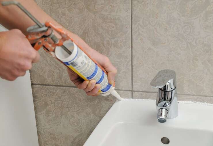 A worker applies silicone sealant