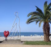 Скульптура "Человек везёт красное сердце на тележке"