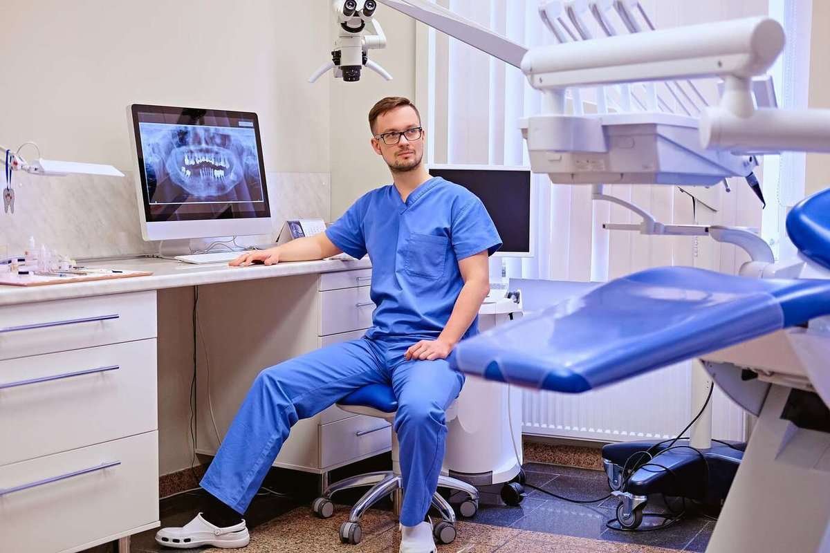 A dentist examines an X-ray of teeth