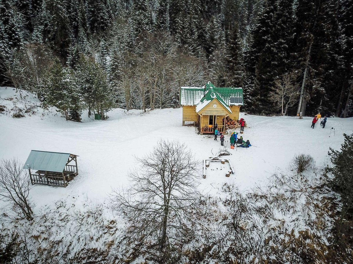 Tourists near a house in Borjomi-Kharagauli National Park in winter.