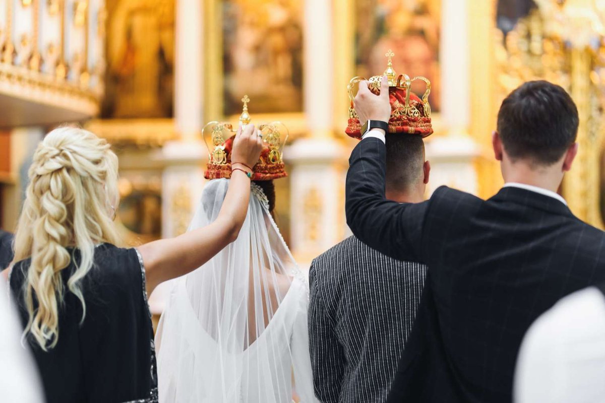 Witnesses hold crowns over the newlyweds during a wedding in a Georgian church.