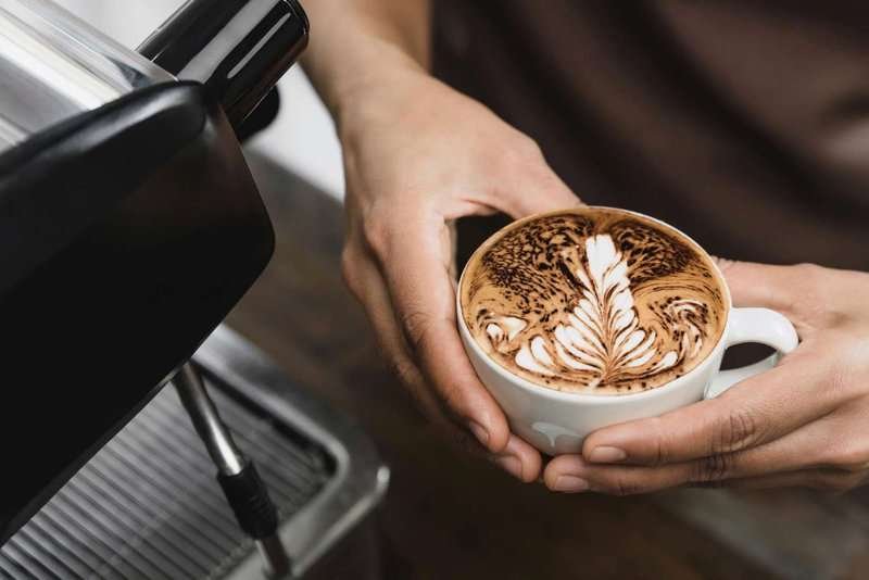 A barista holds a latte