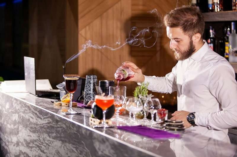 the bartender pours cocktails