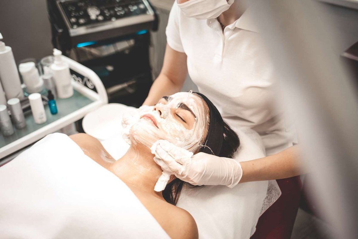 Косметолог смывает маску с пациента