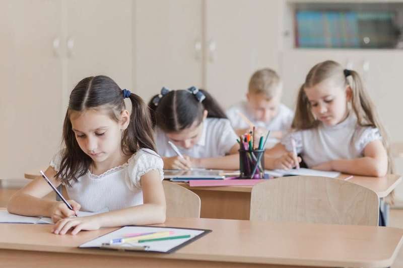 elementary school children complete an assignment in class