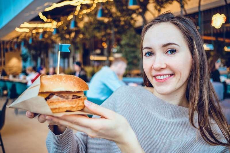 a girl with a burger in a burger shop