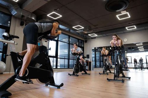 a group of people exercising on exercise bikes in a fitness club