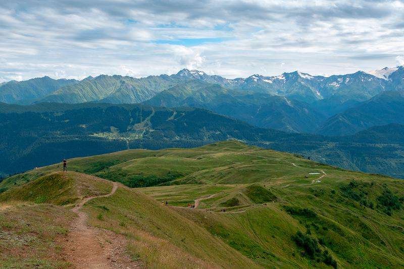 A hiking trail among snow-capped mountains