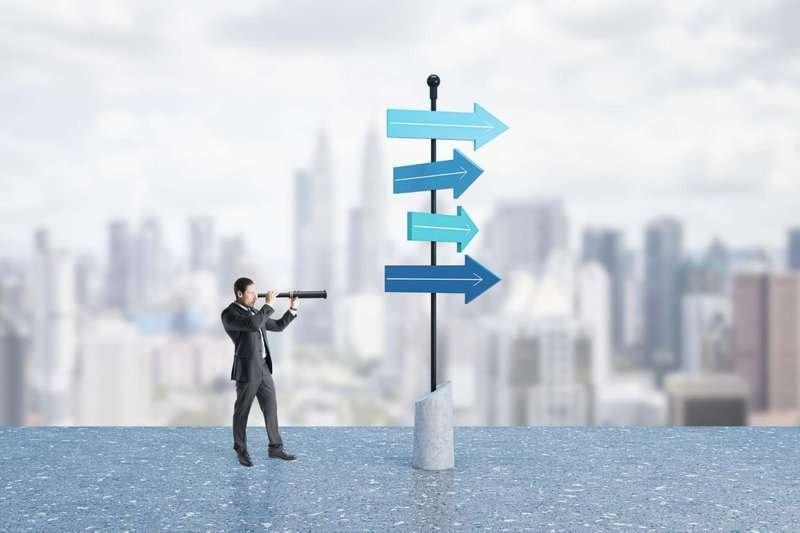 New opportunities concept with businessman on rooftop with sign looking into distance through telescope against city skyline background