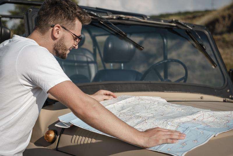 A man checks a map while traveling by car.