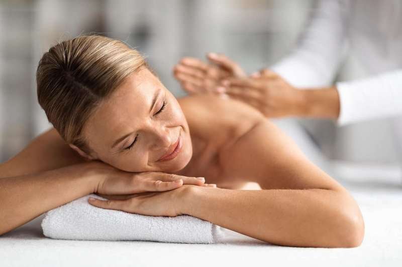 A contented and relaxed woman enjoys a massage