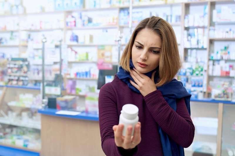 sick-woman-reading-instruction-on-pills-in-d.max-800x600