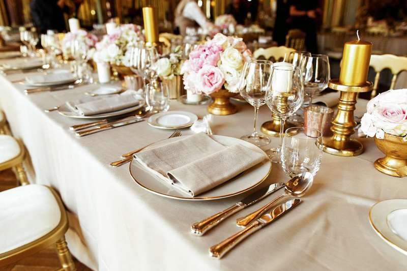 a table set with shiny dishes and cutlery