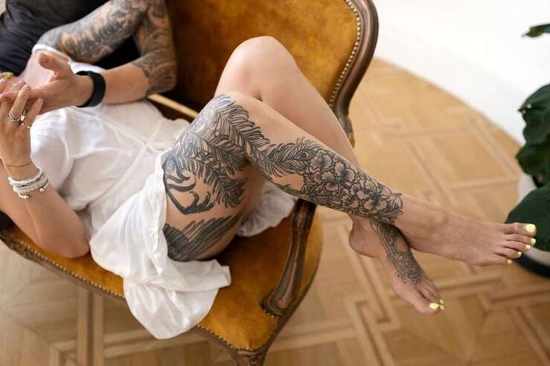 Tattooed people at high angle on a sofa
