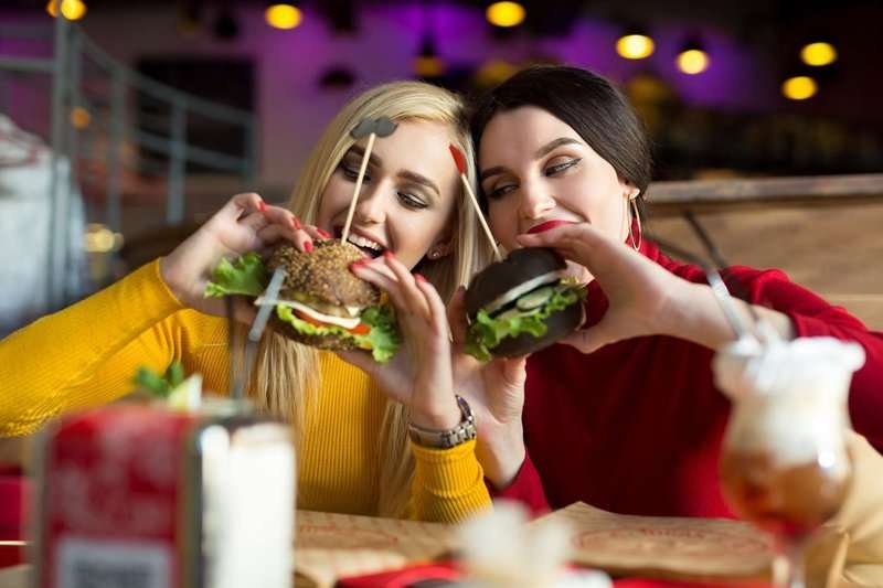 Two girls eating burgers