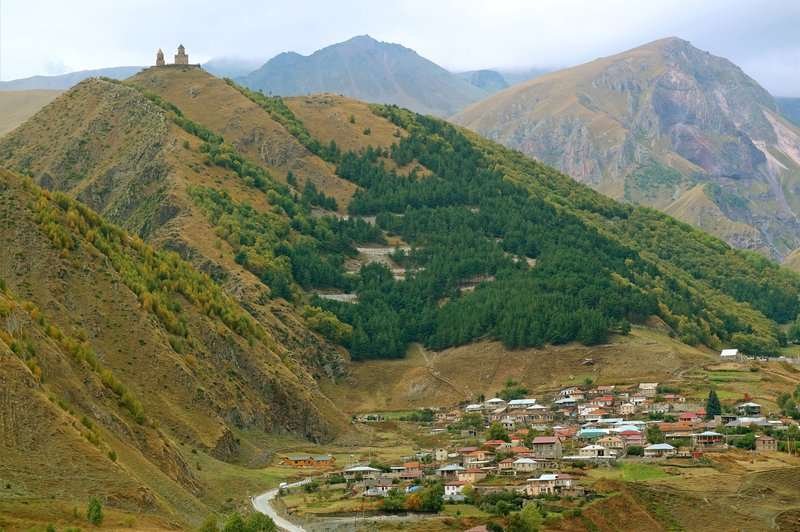 The village of Stepantsminda with a winding road up to the Gergeti Trinity Church