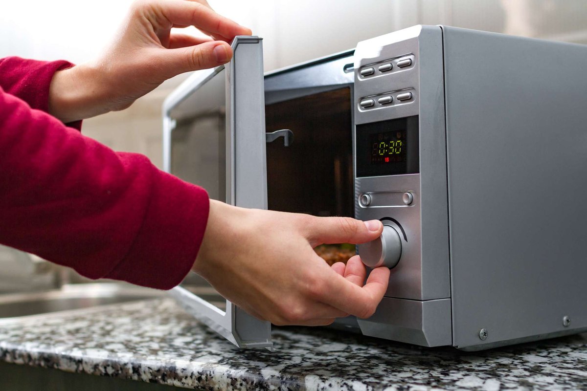 woman-s-hand-closing-the-door-of-the-microwave-.original