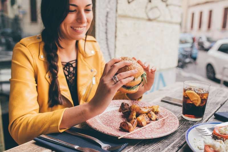 A girl in a restaurant with an ordered burger