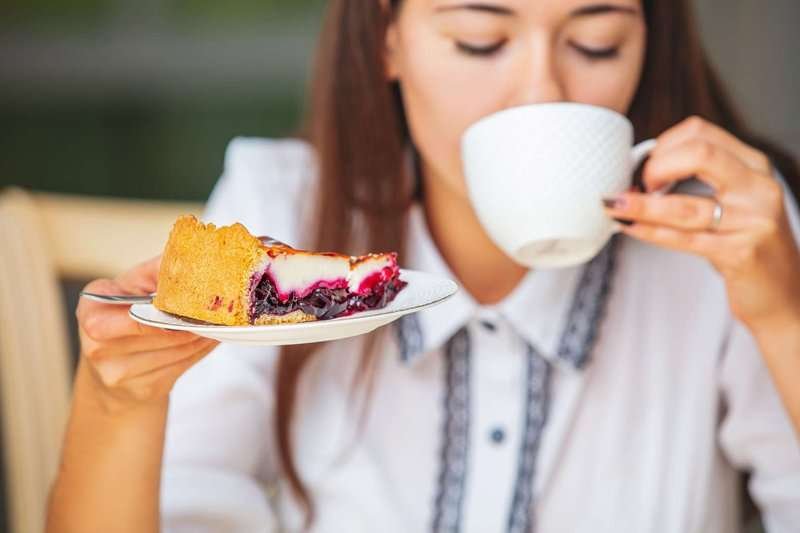 A girl enjoys a delicious dessert and tea