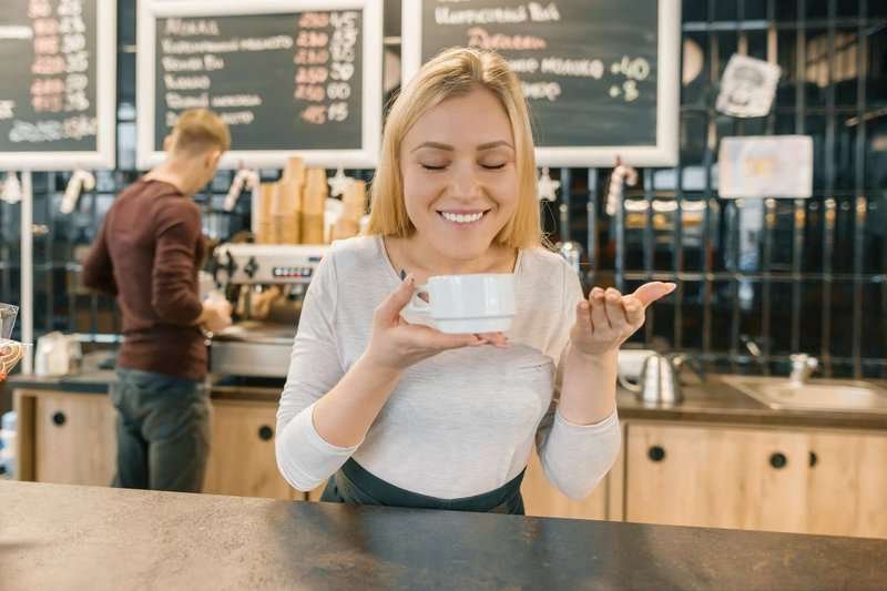 young-smiling-barista-with-cup-coffee800x600