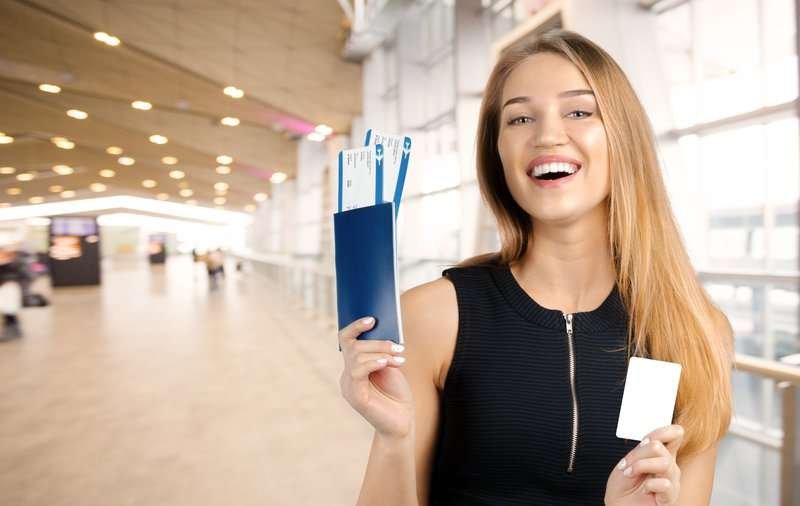young smiling woman keeping airticket