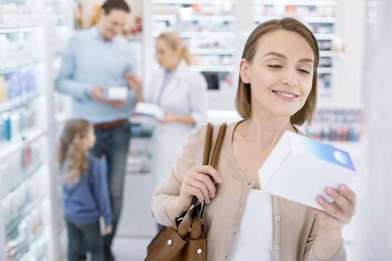 a young woman buys medications at a pharmacy