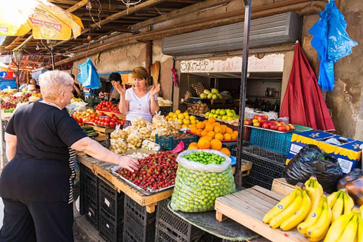 zhenshchina_vybiraet_frukty_na_produktovom_rynk